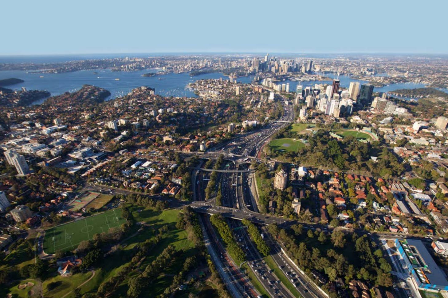 Birds-eye view of the Sydney Warringah Freeway with distant views of the Harbour Bridge in the background.